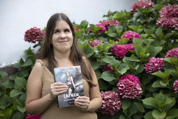 Ana Zabalza Izko, vecina de Arre, posa en el jardín de su casa con su primera novela 'Lafken'.